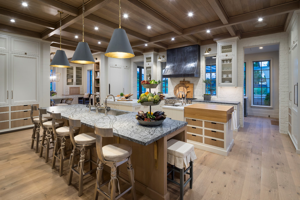 This is an example of an expansive traditional kitchen in Salt Lake City with a submerged sink, white splashback, light hardwood flooring and multiple islands.