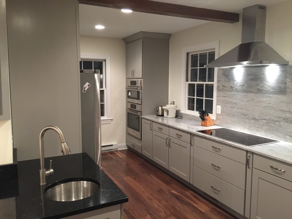 Eat-in kitchen - large transitional l-shaped dark wood floor eat-in kitchen idea in Baltimore with an undermount sink, shaker cabinets, white cabinets, marble countertops, gray backsplash, stone slab backsplash, stainless steel appliances and an island