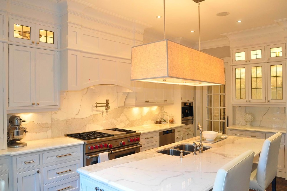 Example of a trendy l-shaped medium tone wood floor eat-in kitchen design in Toronto with an undermount sink, glass-front cabinets, white cabinets, marble countertops, white backsplash, stone slab backsplash, stainless steel appliances and an island