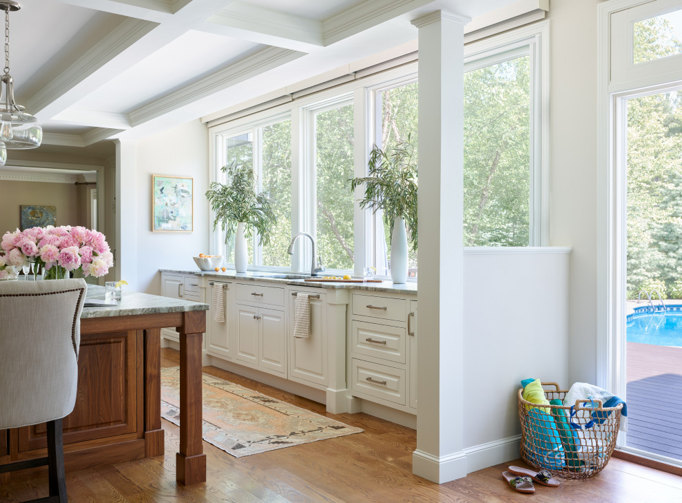 ボストンにある高級な広いトランジショナルスタイルのおしゃれなキッチン (白いキャビネット、珪岩カウンター、無垢フローリング、茶色い床、茶色いキッチンカウンター、格子天井) の写真