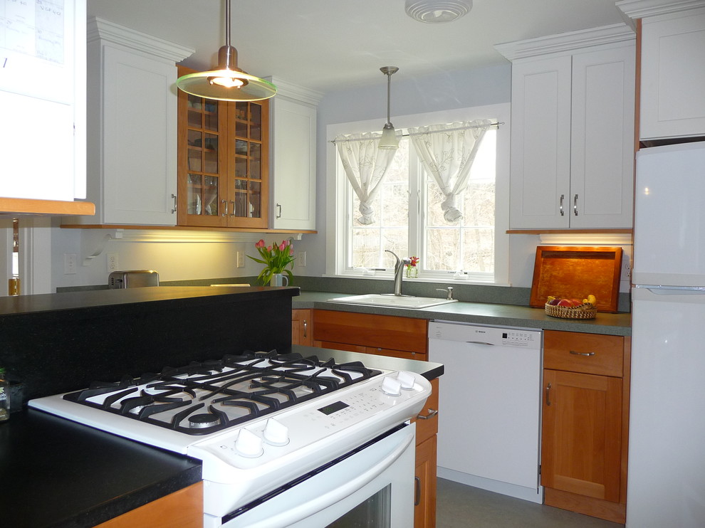 Exempel på ett avskilt, litet klassiskt l-kök, med en nedsänkt diskho, luckor med infälld panel, vita skåp, laminatbänkskiva, grönt stänkskydd, vita vitvaror, linoleumgolv, en halv köksö och grått golv
