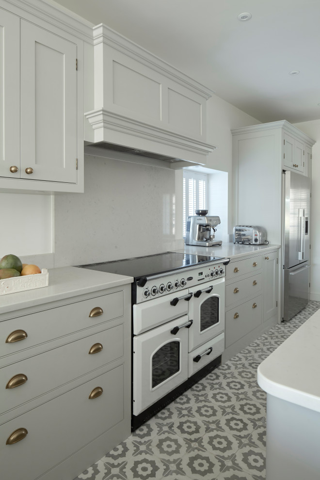 Bild på ett mellanstort vintage vit vitt kök, med en rustik diskho, skåp i shakerstil, grå skåp, bänkskiva i kvartsit, vitt stänkskydd, stänkskydd i sten, vita vitvaror, klinkergolv i keramik, en köksö och grått golv