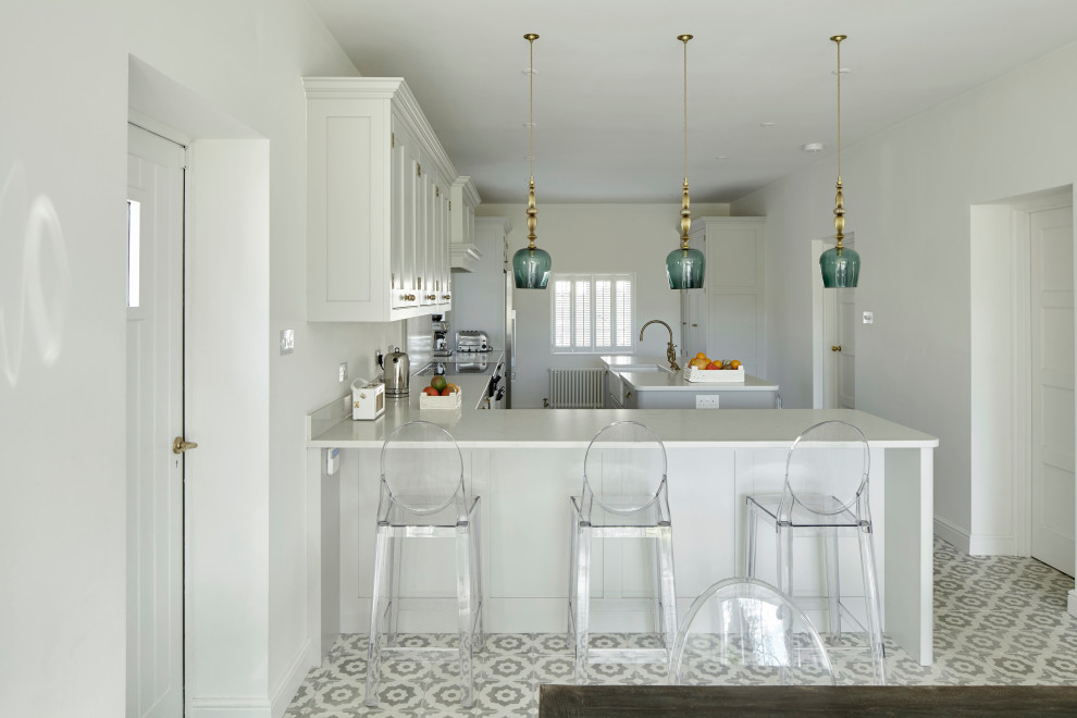 Inspiration for a mid-sized transitional l-shaped ceramic tile and gray floor open concept kitchen remodel in Hampshire with a farmhouse sink, shaker cabinets, gray cabinets, quartzite countertops, white backsplash, stone slab backsplash, stainless steel appliances, an island and white countertops