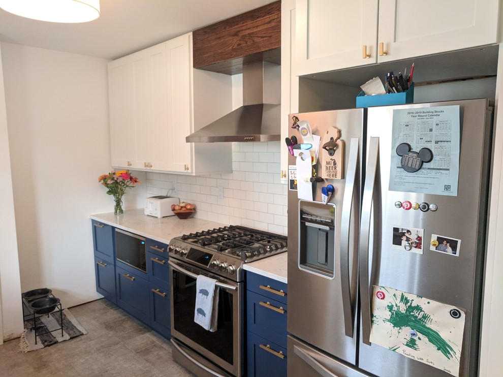 Mid-sized elegant galley vinyl floor and gray floor kitchen pantry photo in Detroit with a farmhouse sink, shaker cabinets, blue cabinets, quartz countertops, white backsplash, subway tile backsplash, stainless steel appliances, no island and white countertops