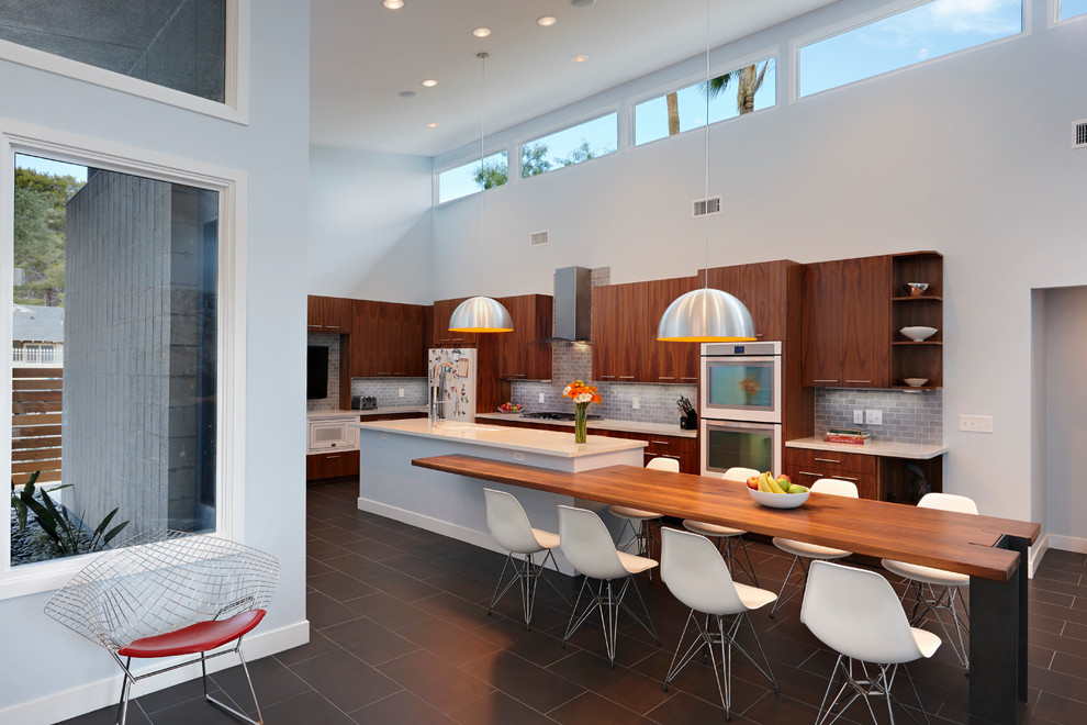 Große Retro Küche in L-Form mit flächenbündigen Schrankfronten, hellbraunen Holzschränken, Küchenrückwand in Grau und Kücheninsel in Las Vegas