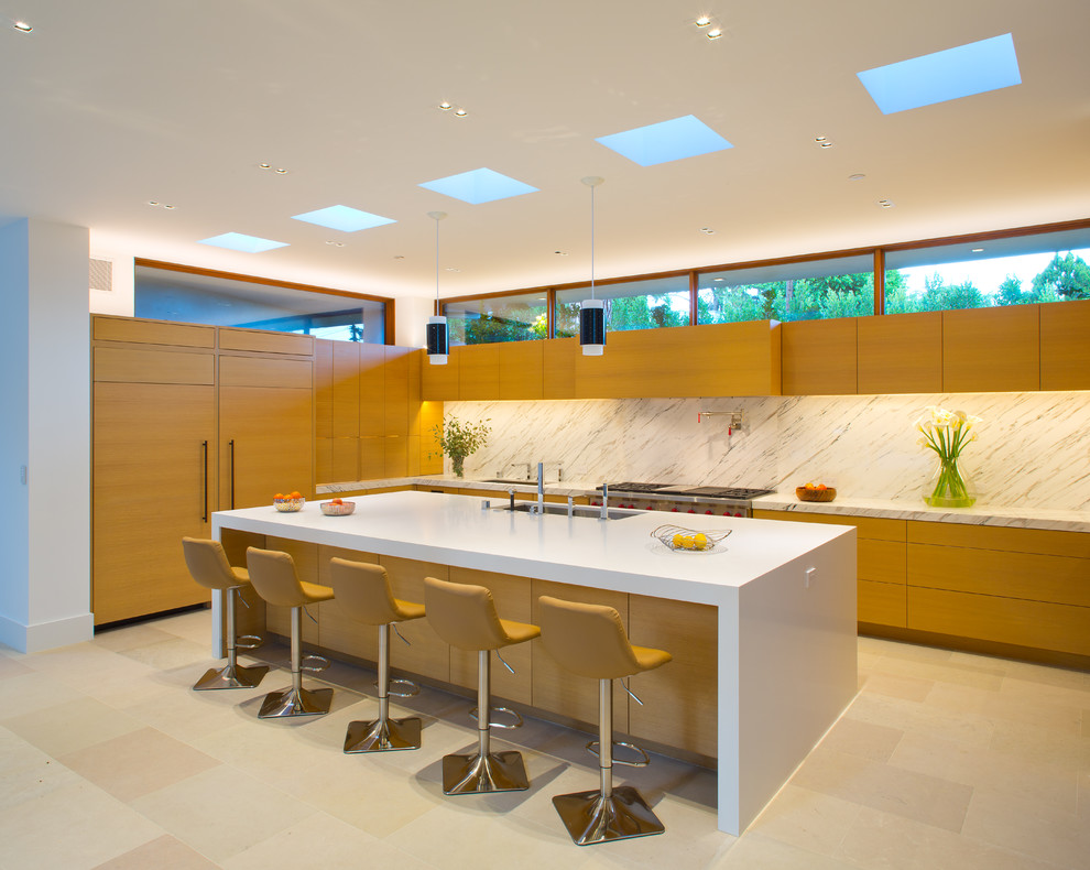 Design ideas for a contemporary l-shaped kitchen in Los Angeles with a submerged sink, flat-panel cabinets, medium wood cabinets, white splashback, integrated appliances and an island.