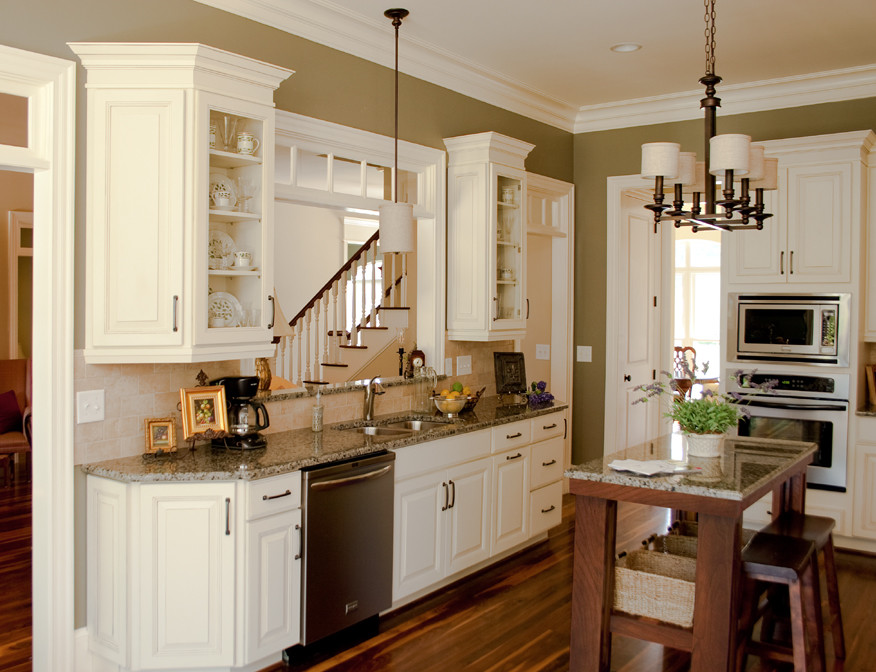 Idéer för att renovera ett avskilt, stort vintage l-kök, med en dubbel diskho, luckor med upphöjd panel, vita skåp, granitbänkskiva, beige stänkskydd, stänkskydd i stenkakel, rostfria vitvaror, mörkt trägolv, en köksö och brunt golv