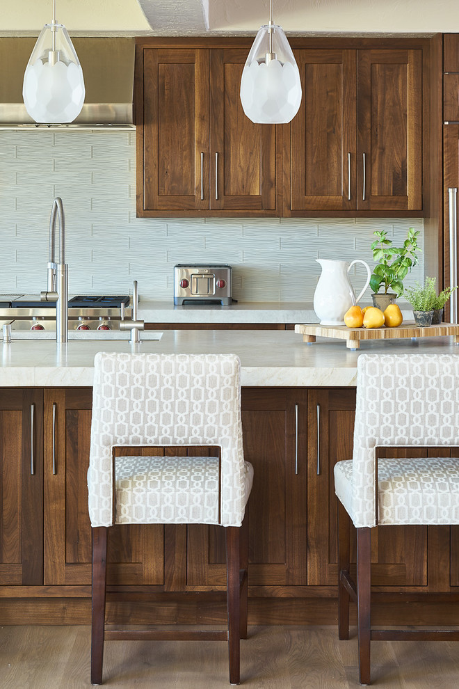 Photo of a classic kitchen in Denver with a single-bowl sink, medium wood cabinets, granite worktops, white splashback, glass tiled splashback, integrated appliances and light hardwood flooring.