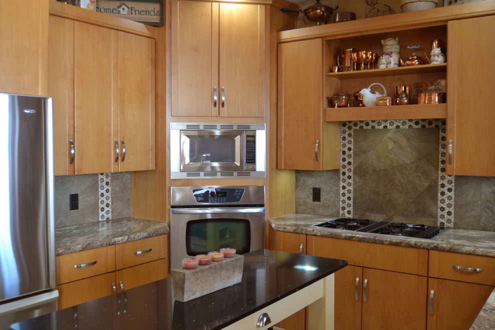 Exempel på ett avskilt, mellanstort klassiskt u-kök, med en undermonterad diskho, släta luckor, skåp i ljust trä, laminatbänkskiva, flerfärgad stänkskydd, stänkskydd i keramik, rostfria vitvaror och en köksö