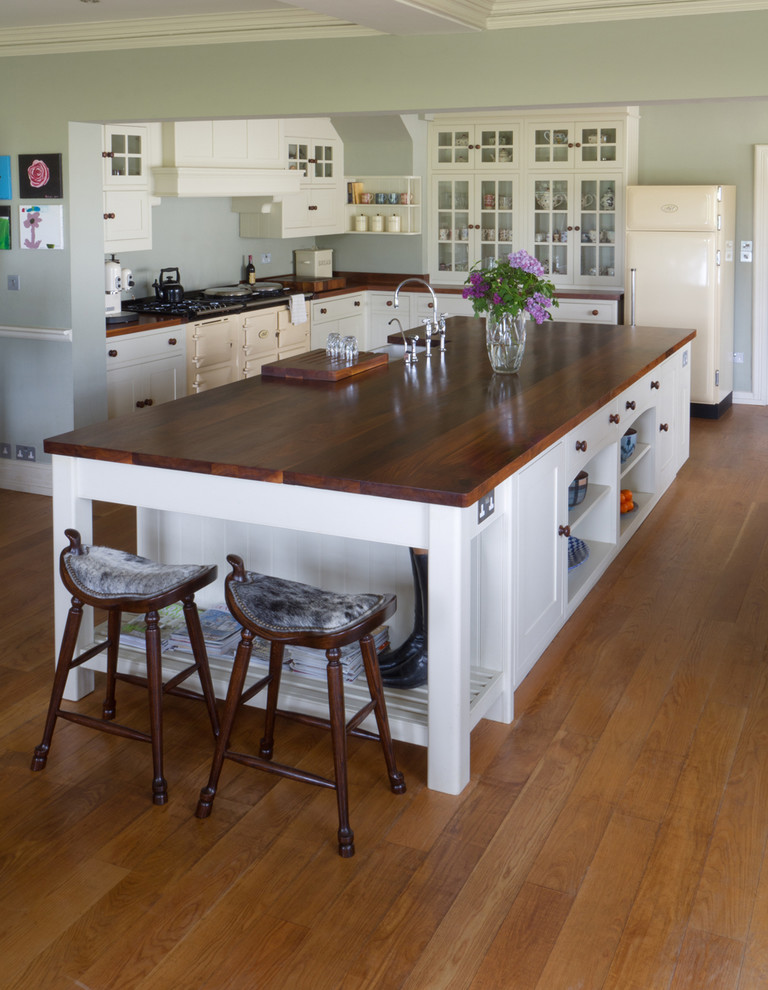Inspiration for a large farmhouse l-shaped kitchen/diner in Other with a submerged sink, shaker cabinets, white cabinets, wood worktops, coloured appliances, medium hardwood flooring and an island.