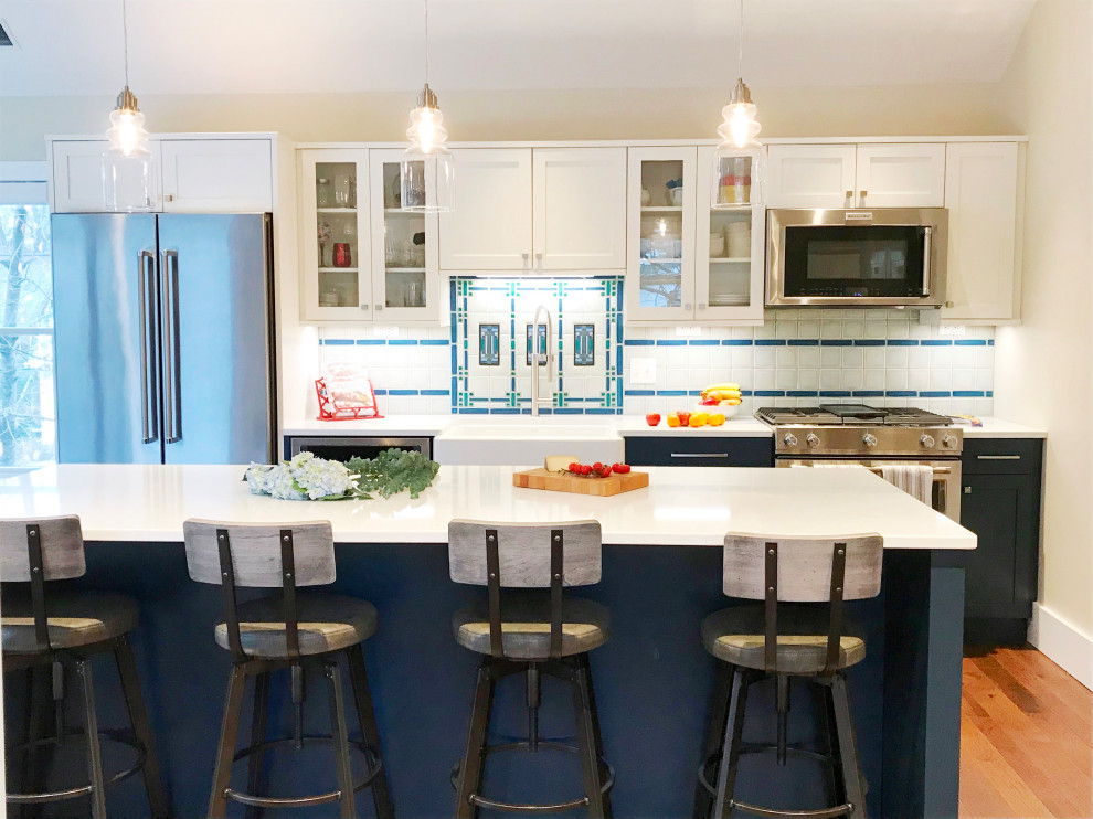 Example of a mid-sized transitional single-wall dark wood floor, brown floor and vaulted ceiling eat-in kitchen design in Detroit with a farmhouse sink, shaker cabinets, quartz countertops, white backsplash, ceramic backsplash, stainless steel appliances, an island and white countertops