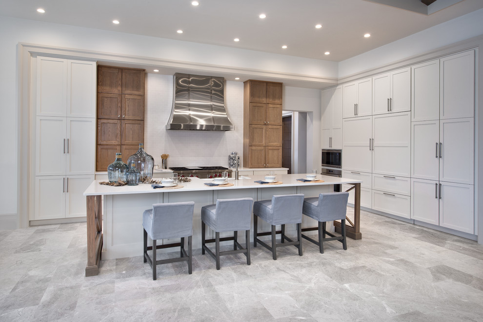 Design ideas for an expansive contemporary single-wall open plan kitchen in Tampa with a belfast sink, shaker cabinets, white cabinets, white splashback, stainless steel appliances and an island.