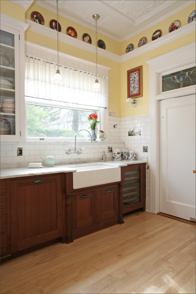 Kitchen - victorian kitchen idea in Portland with subway tile backsplash, marble countertops, a farmhouse sink, dark wood cabinets, white backsplash and paneled appliances