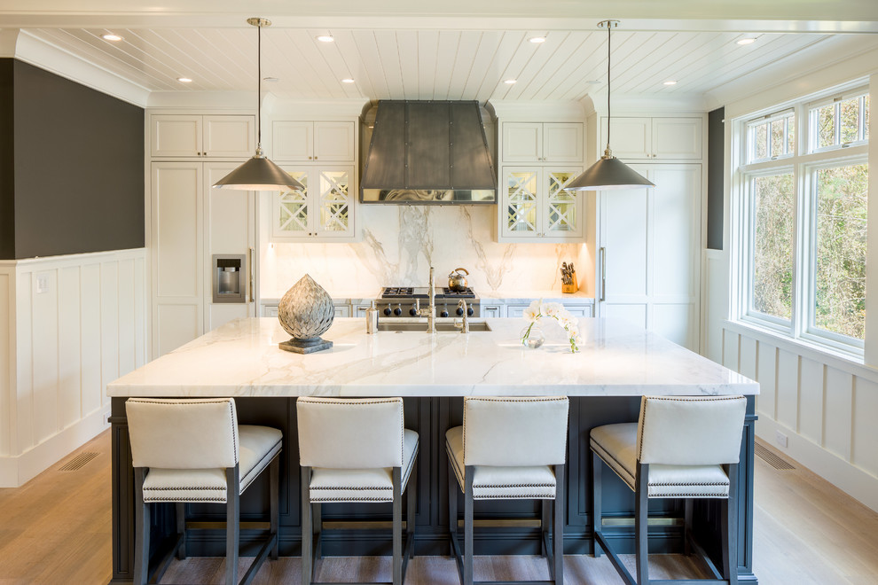 Eat-in kitchen - transitional u-shaped light wood floor and white floor eat-in kitchen idea in Miami with a double-bowl sink, recessed-panel cabinets, white cabinets, white backsplash, marble backsplash, stainless steel appliances and an island