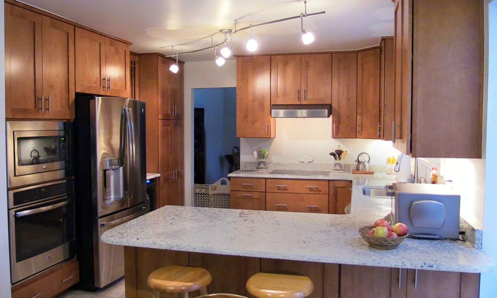 Example of a small classic u-shaped ceramic tile eat-in kitchen design in Baltimore with a double-bowl sink, shaker cabinets, medium tone wood cabinets, granite countertops, white backsplash, stainless steel appliances and no island
