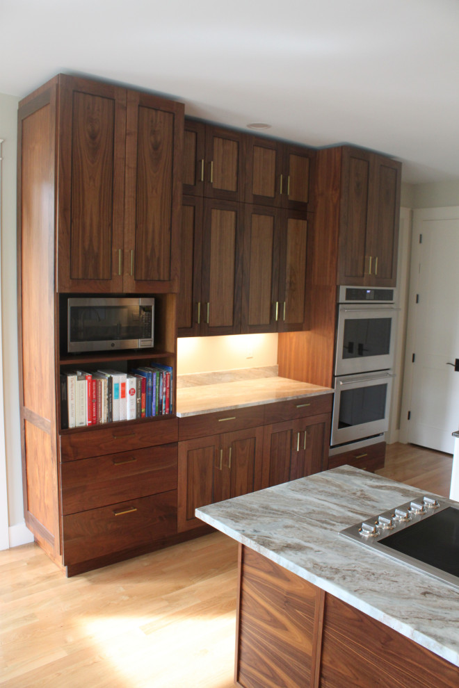 Ejemplo de cocina actual con armarios con paneles empotrados y puertas de armario de madera en tonos medios