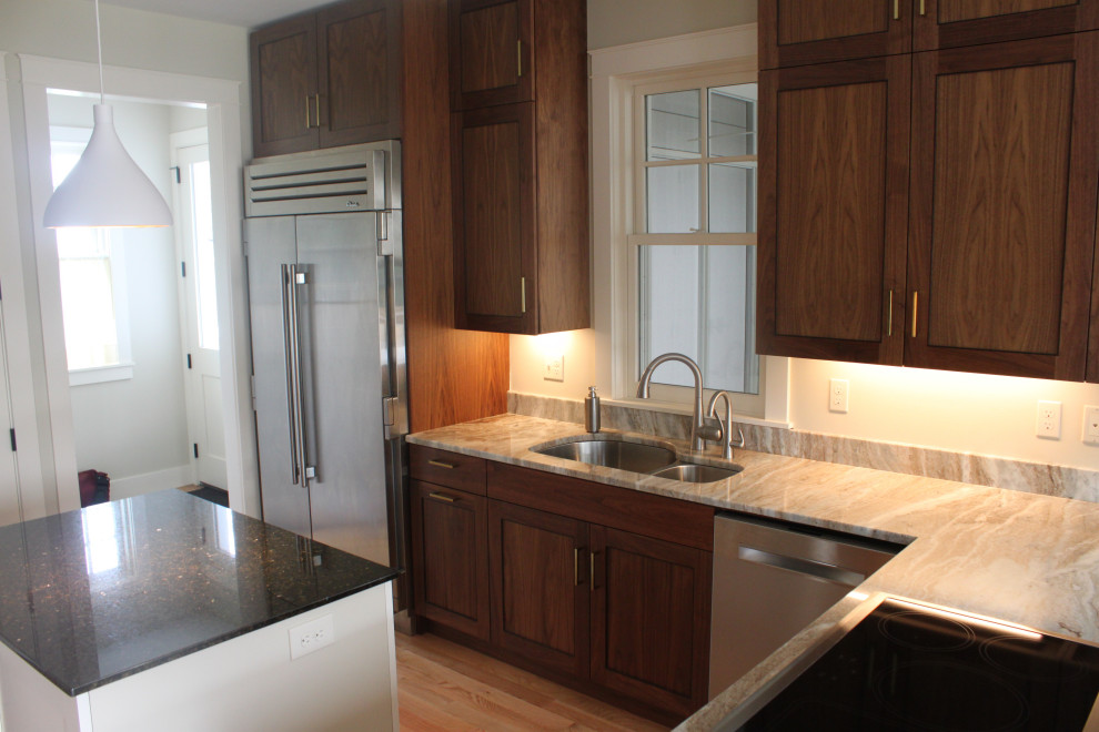 Diseño de cocina actual con armarios con paneles empotrados y puertas de armario de madera en tonos medios
