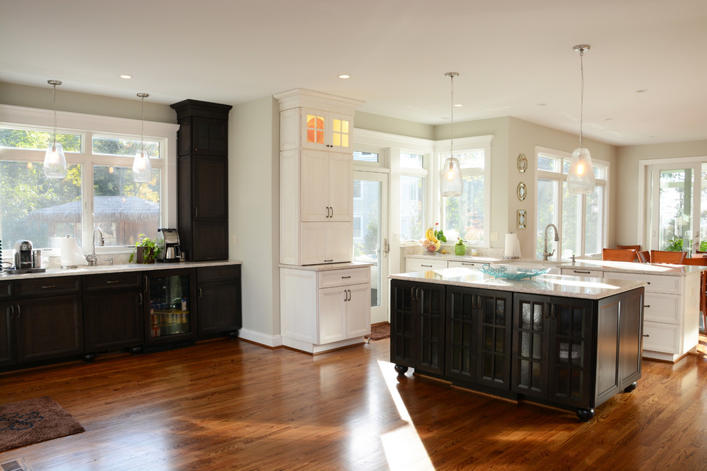 Large elegant u-shaped medium tone wood floor open concept kitchen photo in Baltimore with a farmhouse sink, recessed-panel cabinets, white cabinets, quartz countertops, multicolored backsplash, stainless steel appliances and an island