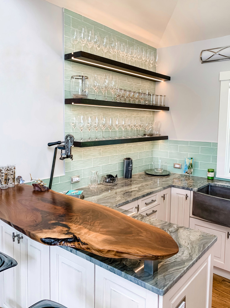 Inredning av ett klassiskt mellanstort flerfärgad flerfärgat kök, med en rustik diskho, luckor med upphöjd panel, vita skåp, granitbänkskiva, blått stänkskydd, stänkskydd i glaskakel, integrerade vitvaror, mellanmörkt trägolv och brunt golv