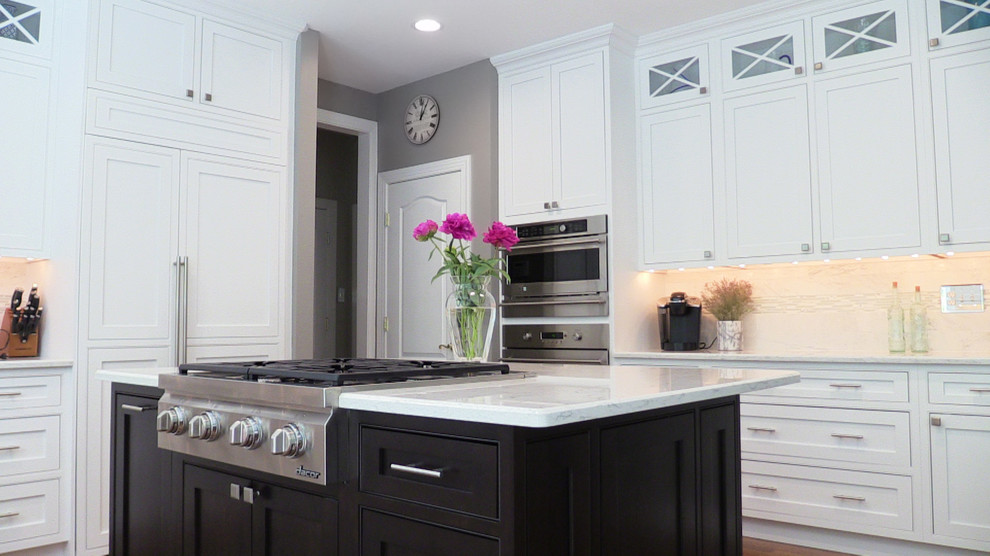 Large elegant u-shaped medium tone wood floor open concept kitchen photo in Baltimore with a single-bowl sink, recessed-panel cabinets, white cabinets, quartz countertops, white backsplash, porcelain backsplash, stainless steel appliances and an island