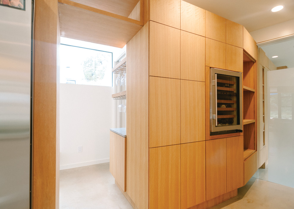 Свежая идея для дизайна: кухня среднего размера в современном стиле с плоскими фасадами и светлыми деревянными фасадами - отличное фото интерьера