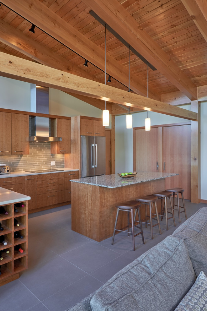 Bild på ett mellanstort funkis kök, med en undermonterad diskho, släta luckor, skåp i mellenmörkt trä, bänkskiva i koppar, grått stänkskydd, stänkskydd i keramik, rostfria vitvaror, betonggolv och en köksö