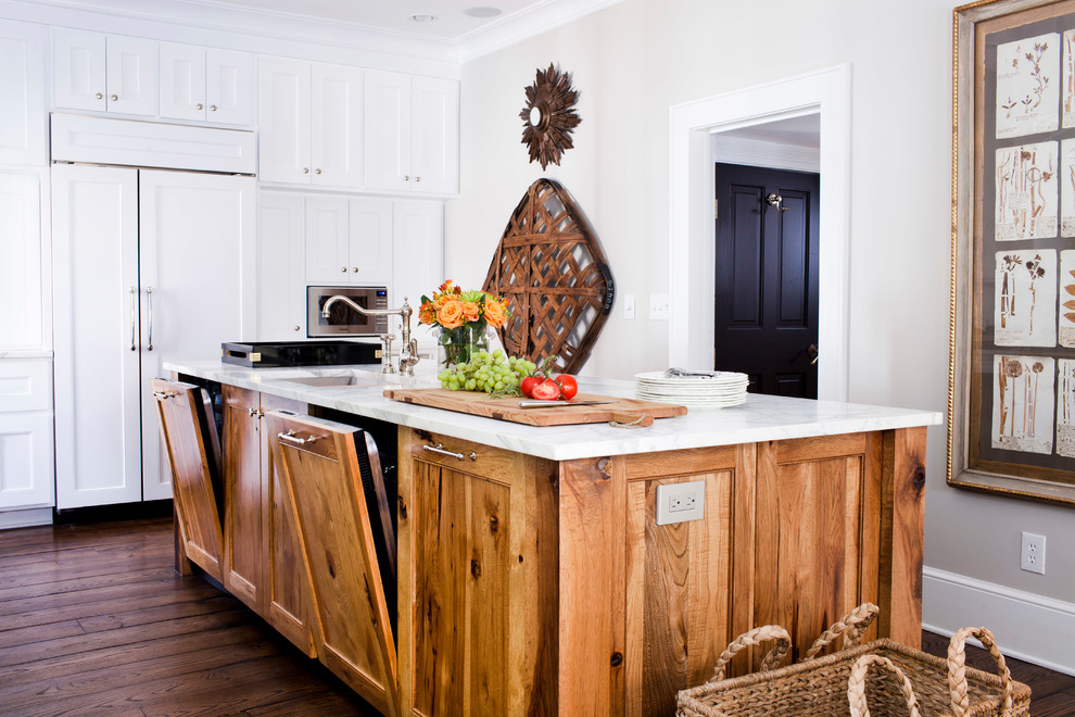 Inspiration for a mid-sized timeless l-shaped medium tone wood floor enclosed kitchen remodel in Atlanta with paneled appliances, an undermount sink, recessed-panel cabinets, white cabinets, marble countertops, white backsplash and an island