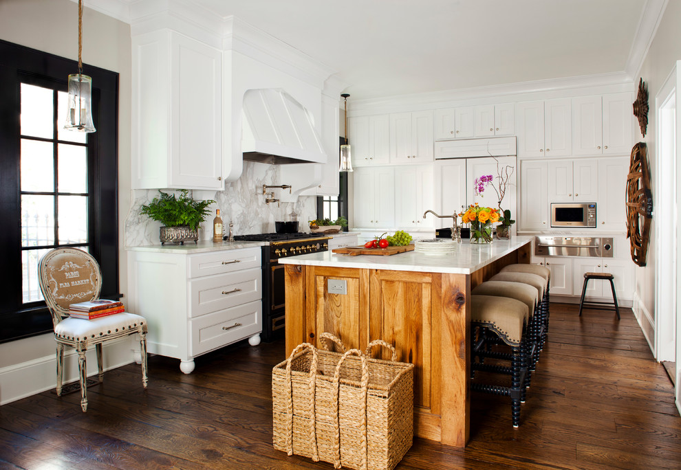 Enclosed kitchen - mid-sized traditional l-shaped medium tone wood floor enclosed kitchen idea in Atlanta with recessed-panel cabinets, white cabinets, white backsplash, stone slab backsplash, black appliances, marble countertops, an undermount sink and an island