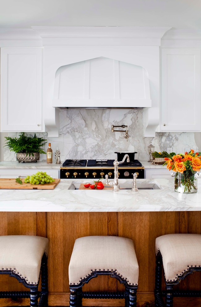 Idéer för mellanstora vintage l-kök, med en undermonterad diskho, marmorbänkskiva, vitt stänkskydd, integrerade vitvaror, luckor med infälld panel, vita skåp, mellanmörkt trägolv, en köksö och stänkskydd i marmor