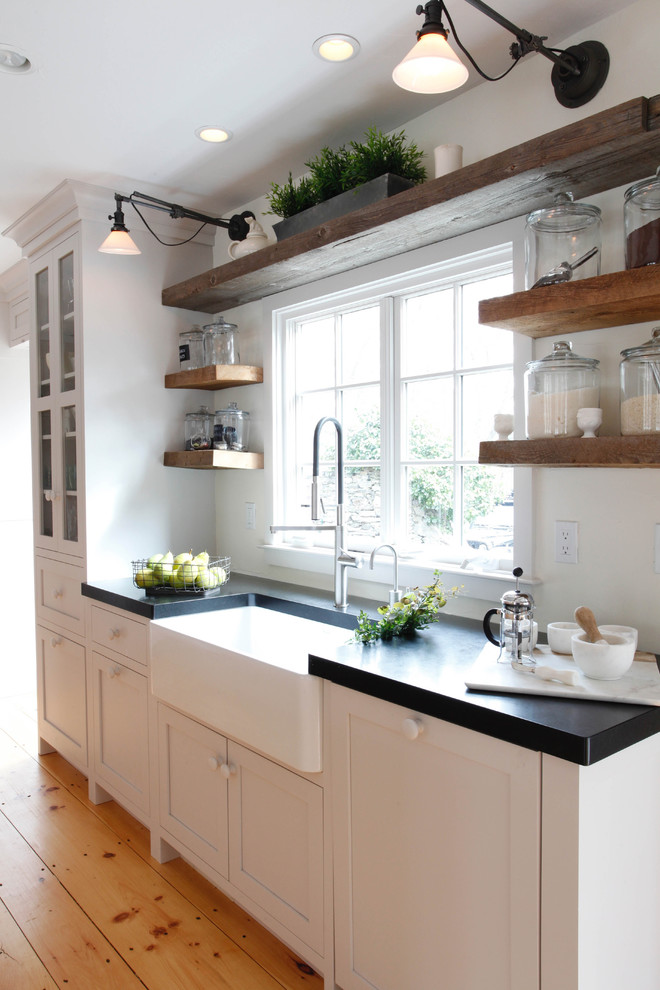 Large farmhouse kitchen pantry in New York with a belfast sink, shaker cabinets, grey cabinets, granite worktops, stainless steel appliances and medium hardwood flooring.