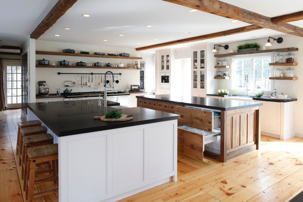 Design ideas for a large rural kitchen pantry in New York with a belfast sink, shaker cabinets, grey cabinets, granite worktops, stainless steel appliances, medium hardwood flooring and multiple islands.