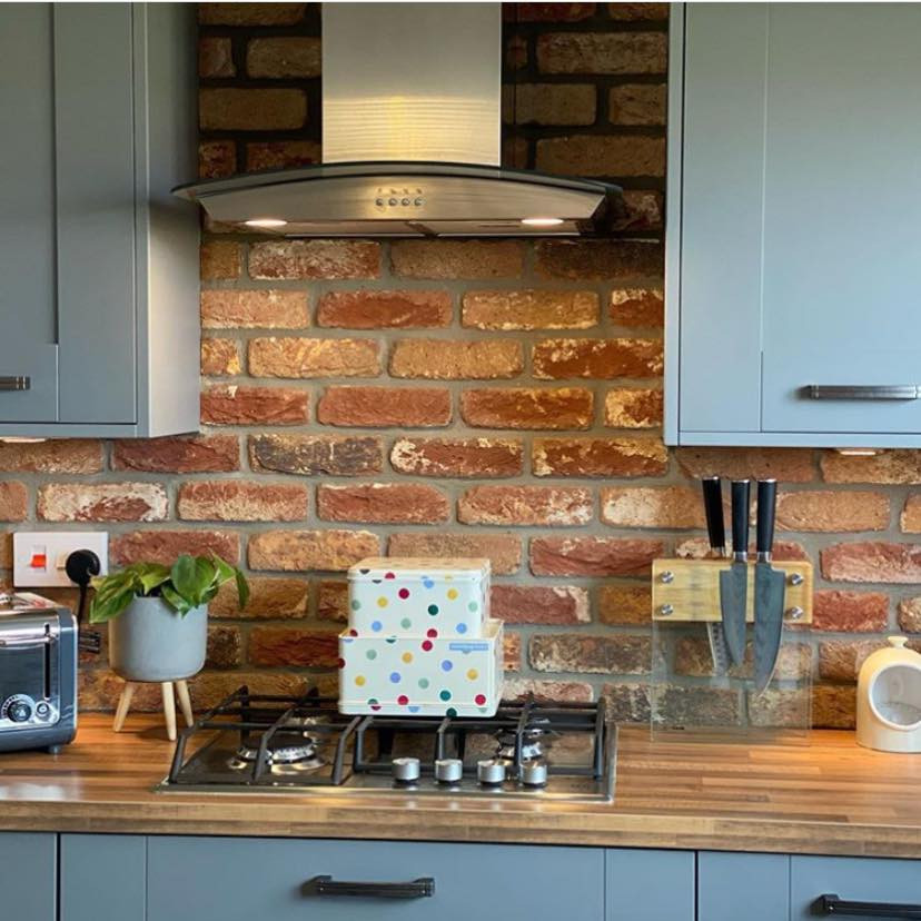 Bild på ett litet rustikt linjärt kök och matrum, med skåp i shakerstil, grå skåp, träbänkskiva, stänkskydd i tegel, integrerade vitvaror, en köksö och en dubbel diskho
