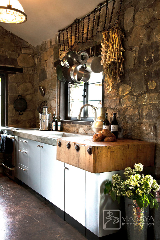 Idéer för ett litet rustikt linjärt kök med öppen planlösning, med en integrerad diskho, släta luckor, skåp i rostfritt stål, bänkskiva i betong, betonggolv, en köksö, beige stänkskydd och rostfria vitvaror
