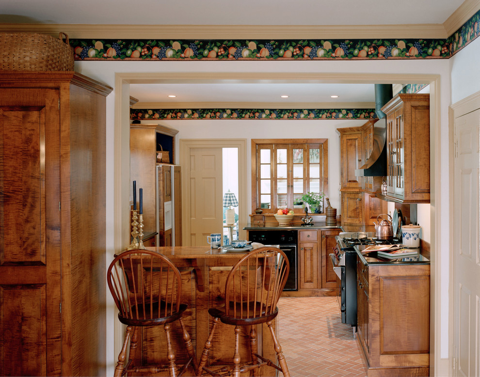 Bild på ett mellanstort vintage kök och matrum, med svarta vitvaror, klinkergolv i terrakotta, en dubbel diskho, luckor med profilerade fronter, skåp i mellenmörkt trä, bänkskiva i glas och en halv köksö