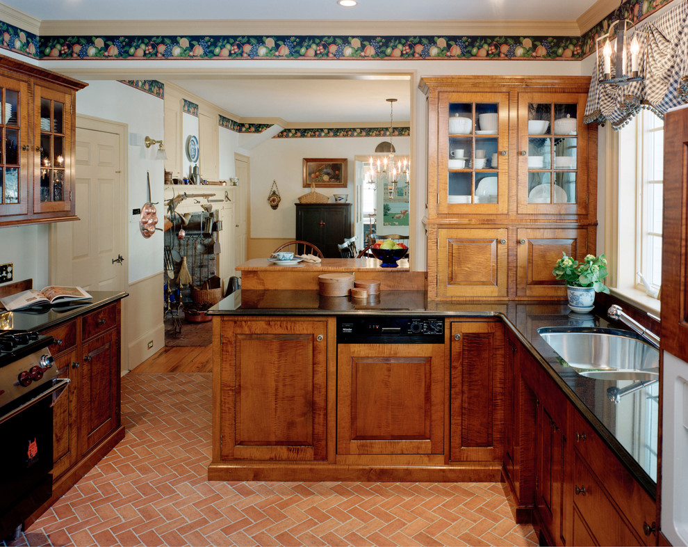 Immagine di una cucina abitabile tradizionale di medie dimensioni con lavello a doppia vasca, ante con bugna sagomata, ante in legno scuro, top in granito, elettrodomestici in acciaio inossidabile e pavimento in terracotta