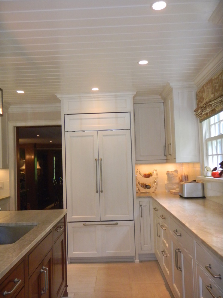 Large transitional l-shaped limestone floor open concept kitchen photo in New York with an undermount sink, beaded inset cabinets, white cabinets, quartzite countertops, white backsplash, ceramic backsplash, paneled appliances and an island