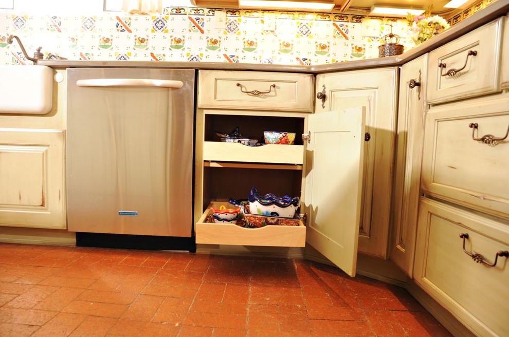 Example of a mid-sized southwest u-shaped terra-cotta tile enclosed kitchen design in Albuquerque with a farmhouse sink, raised-panel cabinets, green cabinets, solid surface countertops, multicolored backsplash, mosaic tile backsplash, stainless steel appliances and an island