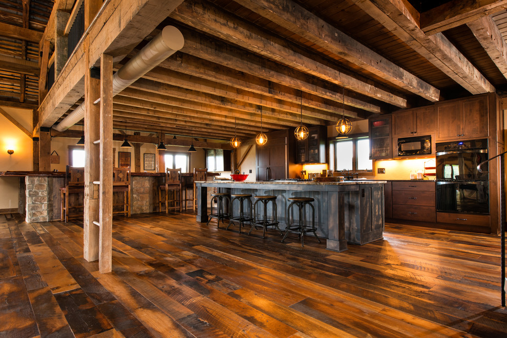 Foto di un'ampia cucina rustica con ante in legno bruno, paraspruzzi beige, elettrodomestici neri e pavimento in legno massello medio