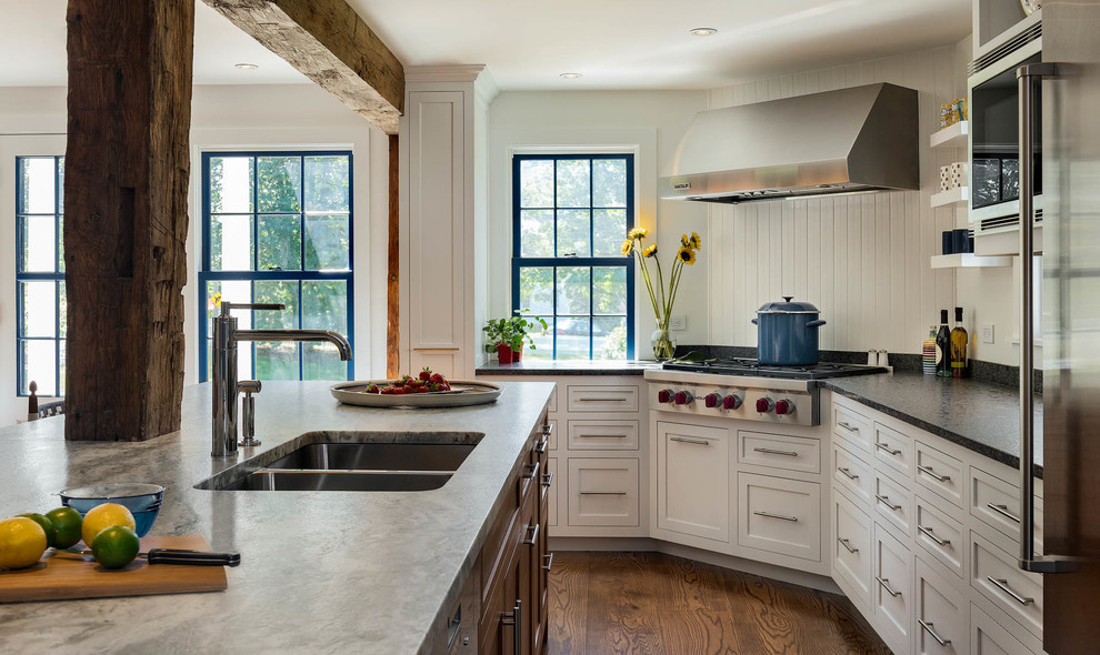 Bild på ett stort vintage kök, med en undermonterad diskho, skåp i shakerstil, vita skåp, vitt stänkskydd, stänkskydd i trä, rostfria vitvaror, mellanmörkt trägolv, en köksö, brunt golv och granitbänkskiva