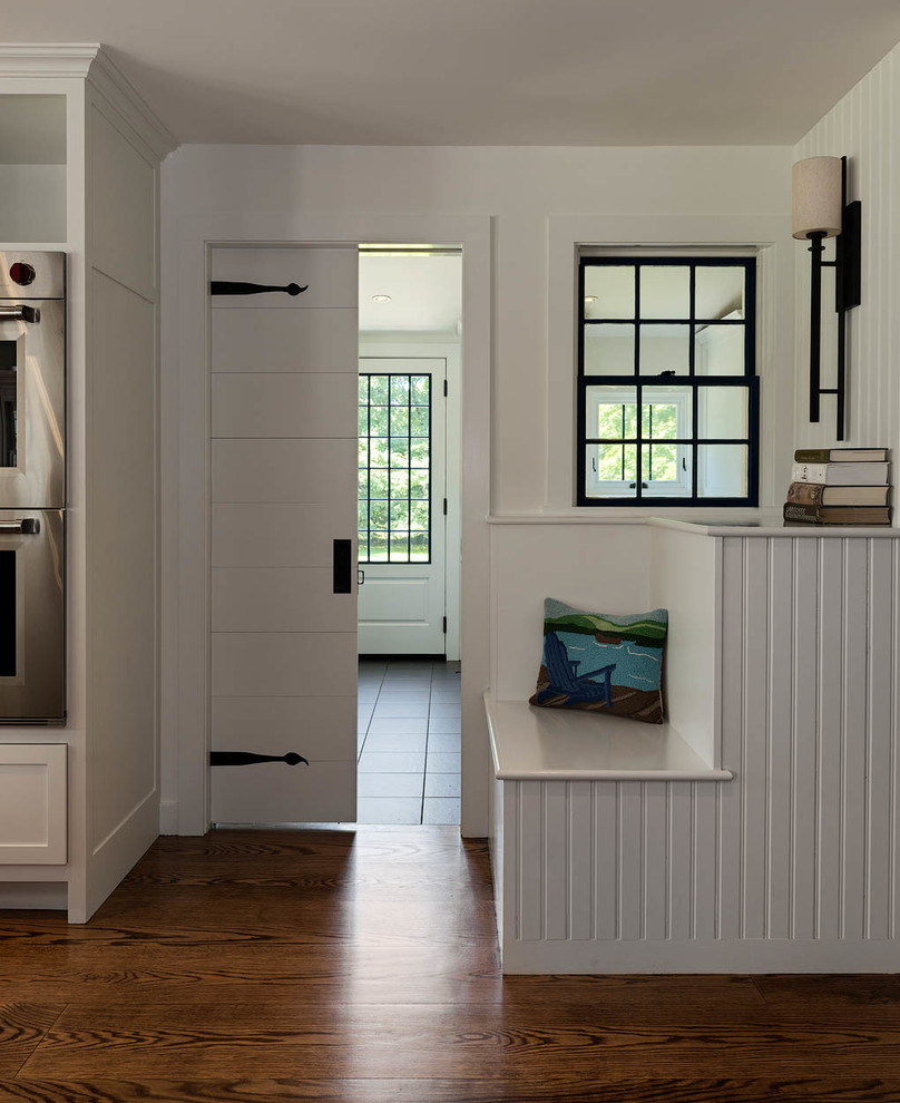 Bild på ett stort eklektiskt kök, med en undermonterad diskho, skåp i shakerstil, vita skåp, granitbänkskiva, vitt stänkskydd, stänkskydd i trä, rostfria vitvaror, mellanmörkt trägolv, en köksö och brunt golv