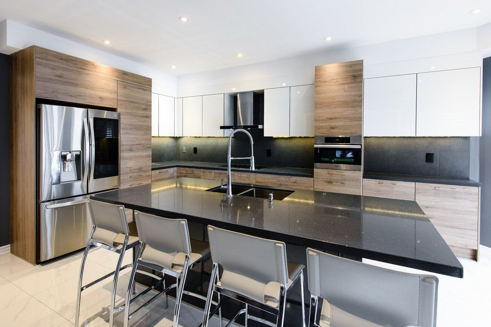 Foto di una cucina minimalista di medie dimensioni con lavello sottopiano, ante lisce, ante in legno scuro, paraspruzzi nero, elettrodomestici in acciaio inossidabile, pavimento beige e top nero