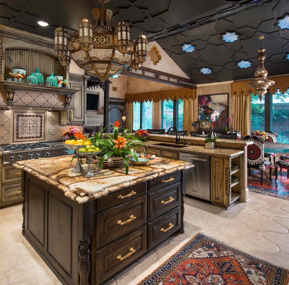 Kitchen - mediterranean u-shaped kitchen idea in Dallas with raised-panel cabinets, distressed cabinets, beige backsplash, stainless steel appliances and an island