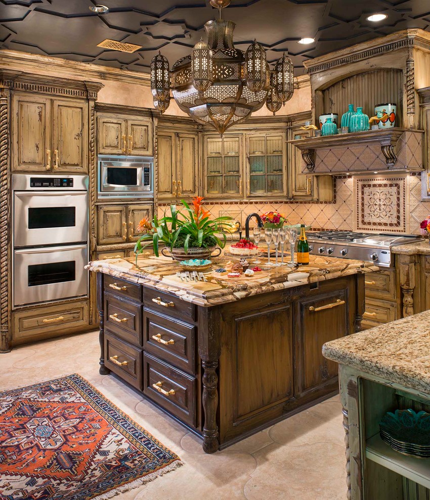 Tuscan u-shaped kitchen photo in Dallas with raised-panel cabinets, distressed cabinets, beige backsplash, stainless steel appliances and an island