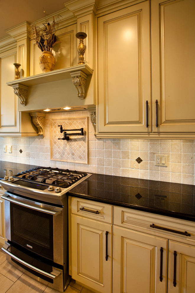 Example of a classic l-shaped eat-in kitchen design in Vancouver with an undermount sink, raised-panel cabinets, white cabinets, granite countertops, multicolored backsplash, mosaic tile backsplash and stainless steel appliances