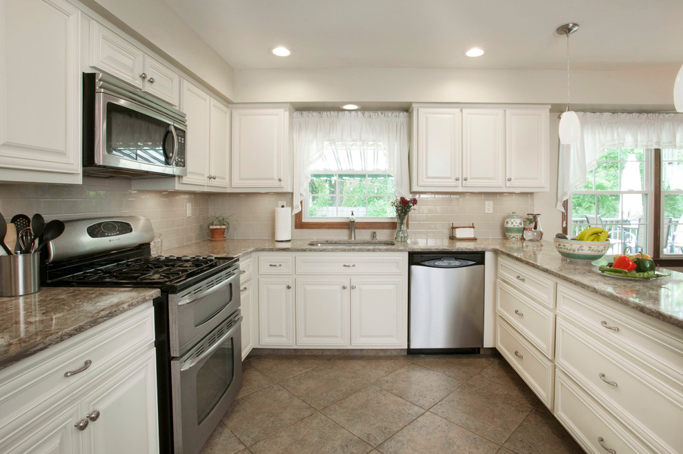 Example of a mid-sized classic u-shaped ceramic tile and brown floor eat-in kitchen design in Philadelphia with a single-bowl sink, raised-panel cabinets, beige cabinets, quartzite countertops, beige backsplash, glass tile backsplash and stainless steel appliances