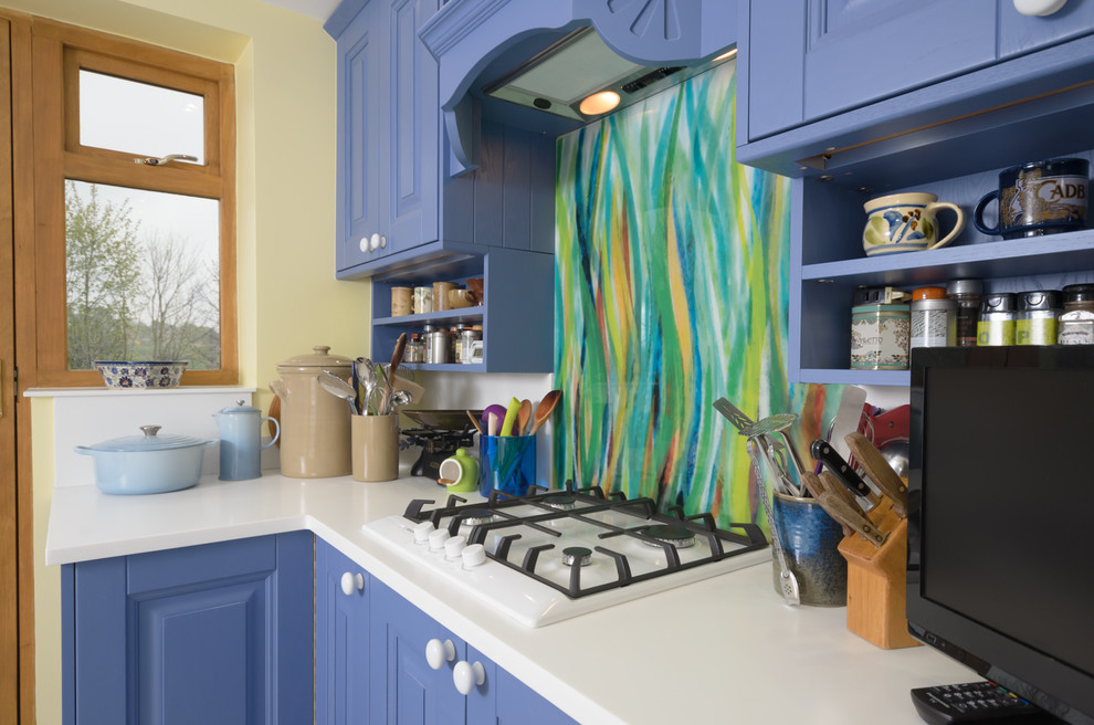 Esempio di una piccola cucina ad ambiente unico bohémian con ante blu, top in legno, paraspruzzi multicolore, paraspruzzi con lastra di vetro e pavimento in laminato