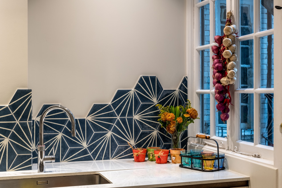 Inspiration for a large eclectic l-shaped ceramic tile and gray floor enclosed kitchen remodel in London with a single-bowl sink, flat-panel cabinets, gray cabinets, marble countertops, blue backsplash, cement tile backsplash, paneled appliances, no island and white countertops