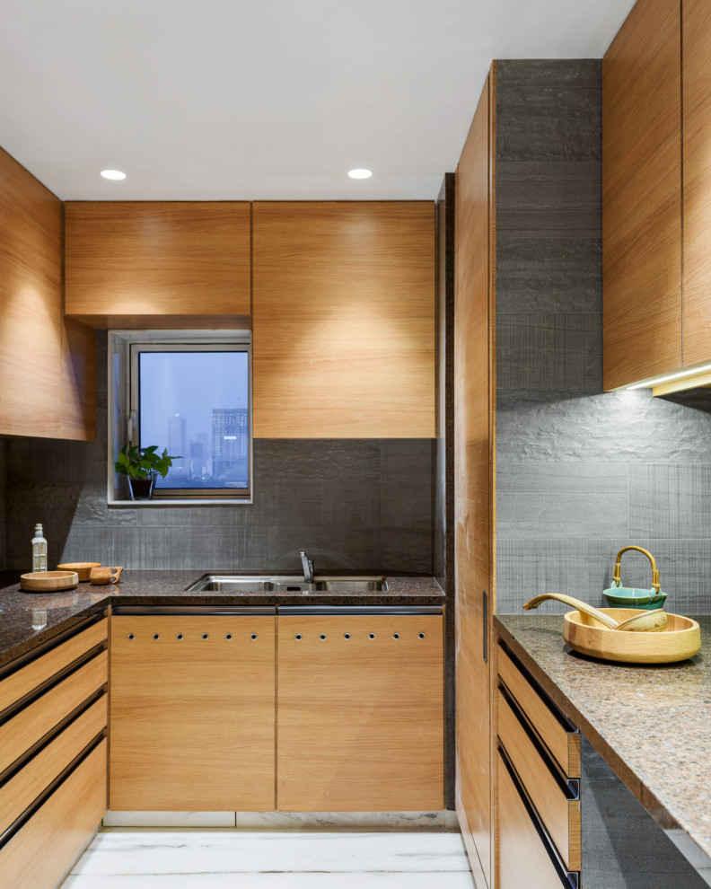 Источник вдохновения для домашнего уюта: п-образная кухня в современном стиле с врезной мойкой, плоскими фасадами, светлыми деревянными фасадами, серым фартуком, разноцветным полом и коричневой столешницей