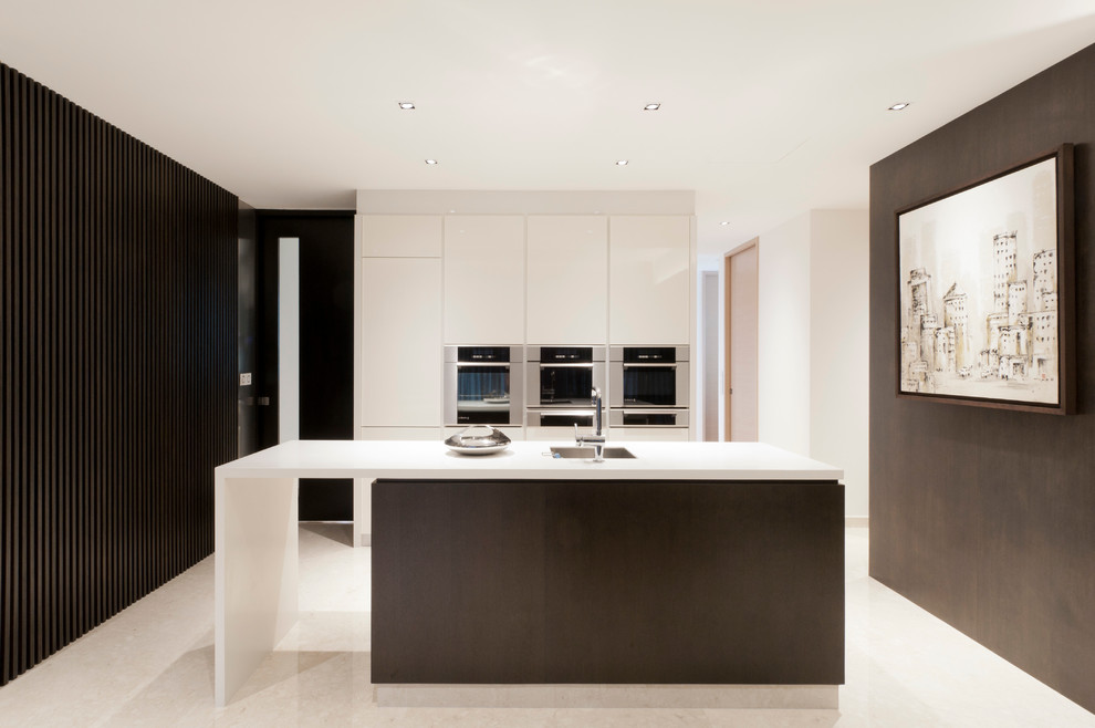 Cette image montre une cuisine parallèle design avec un placard à porte plane et des portes de placard blanches.