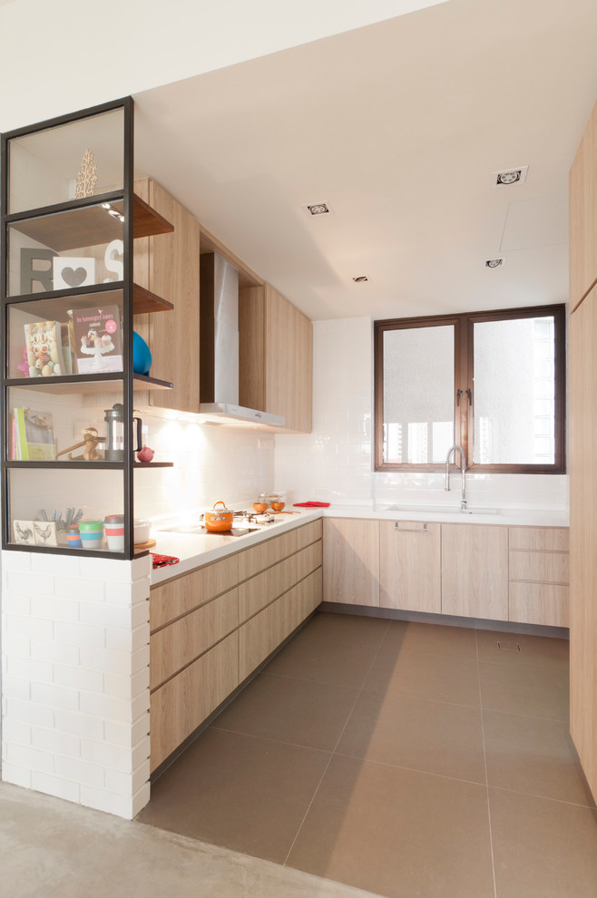 На фото: кухня в современном стиле с плоскими фасадами, светлыми деревянными фасадами, белым фартуком и окном с